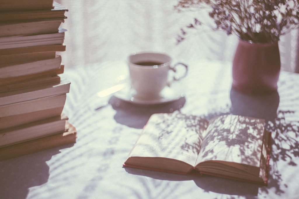 Libri aperti e una tazza nella luce del mattino